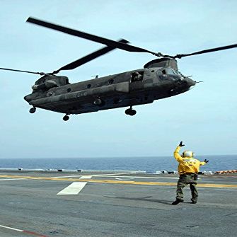 Airman directs an Army CH-47 Chinook helicopter on the flight deck Poster Print by Stocktrek Images (22 x 34)