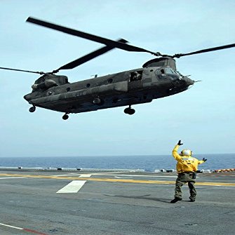Airman directs an Army CH-47 Chinook helicopter on the flight deck Poster Print by Stocktrek Images (22 x 34)