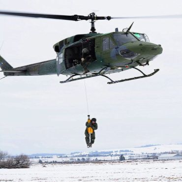 A student is hoisted into a UH-1N Iroquois during a training exercise Poster Print by Stocktrek Images (22 x 34)